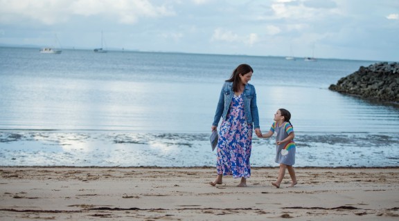 Mother and daughter walking along the beach