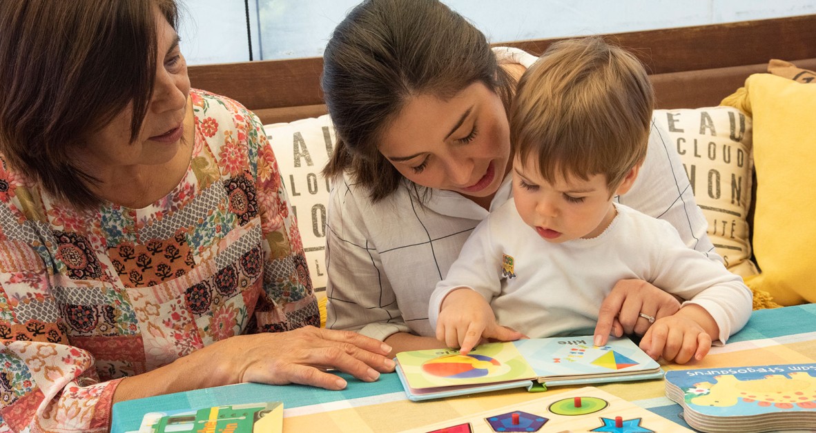 Two woman reading to a learning child