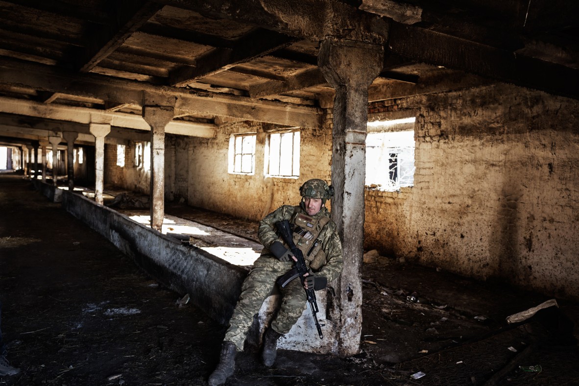 A photo of a soldier leaning against a pylon in a brick building