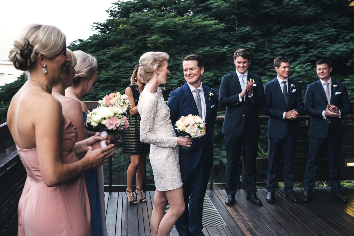 Wedding party standing toether outside on the River Decks at State Library.