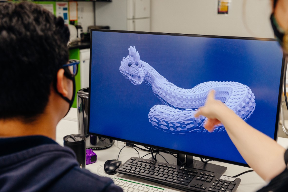 Student using a computer to design a 3D dragon