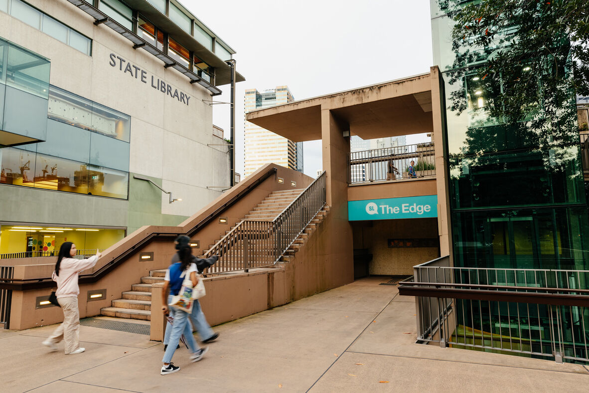 A photo of people walking towards a building with The Edge signage