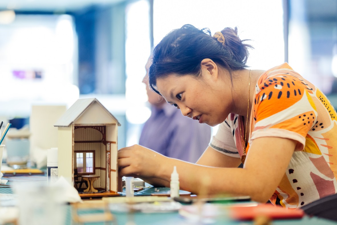 A photo of someone making their Queensland Architecture in miniature book nook