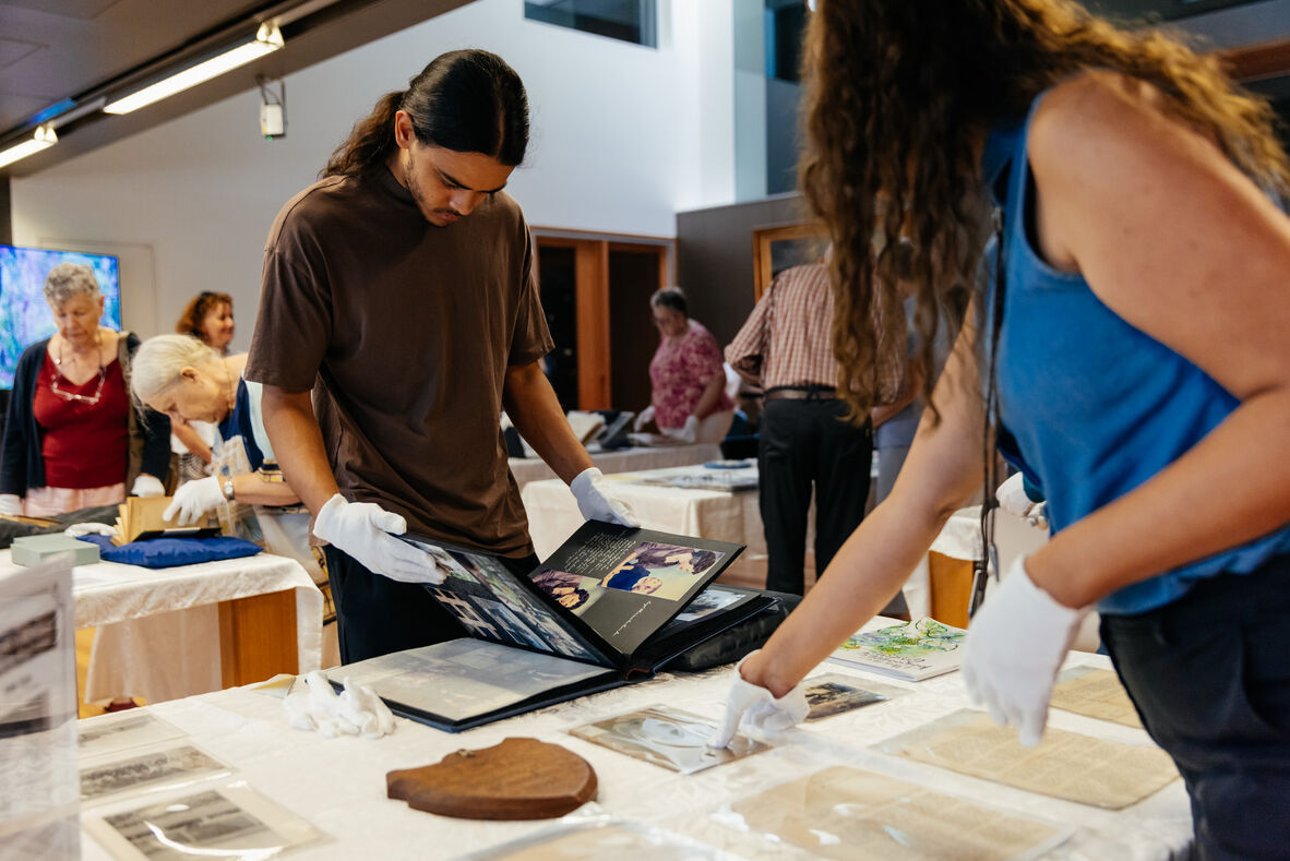 People viewing collections at Research Reveals event, State Library of Queensland