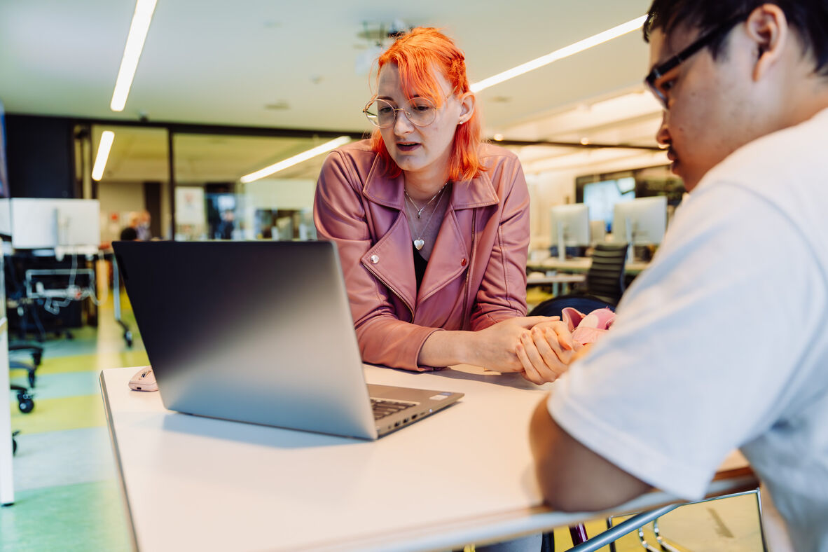 A photo of people looking at a laptop