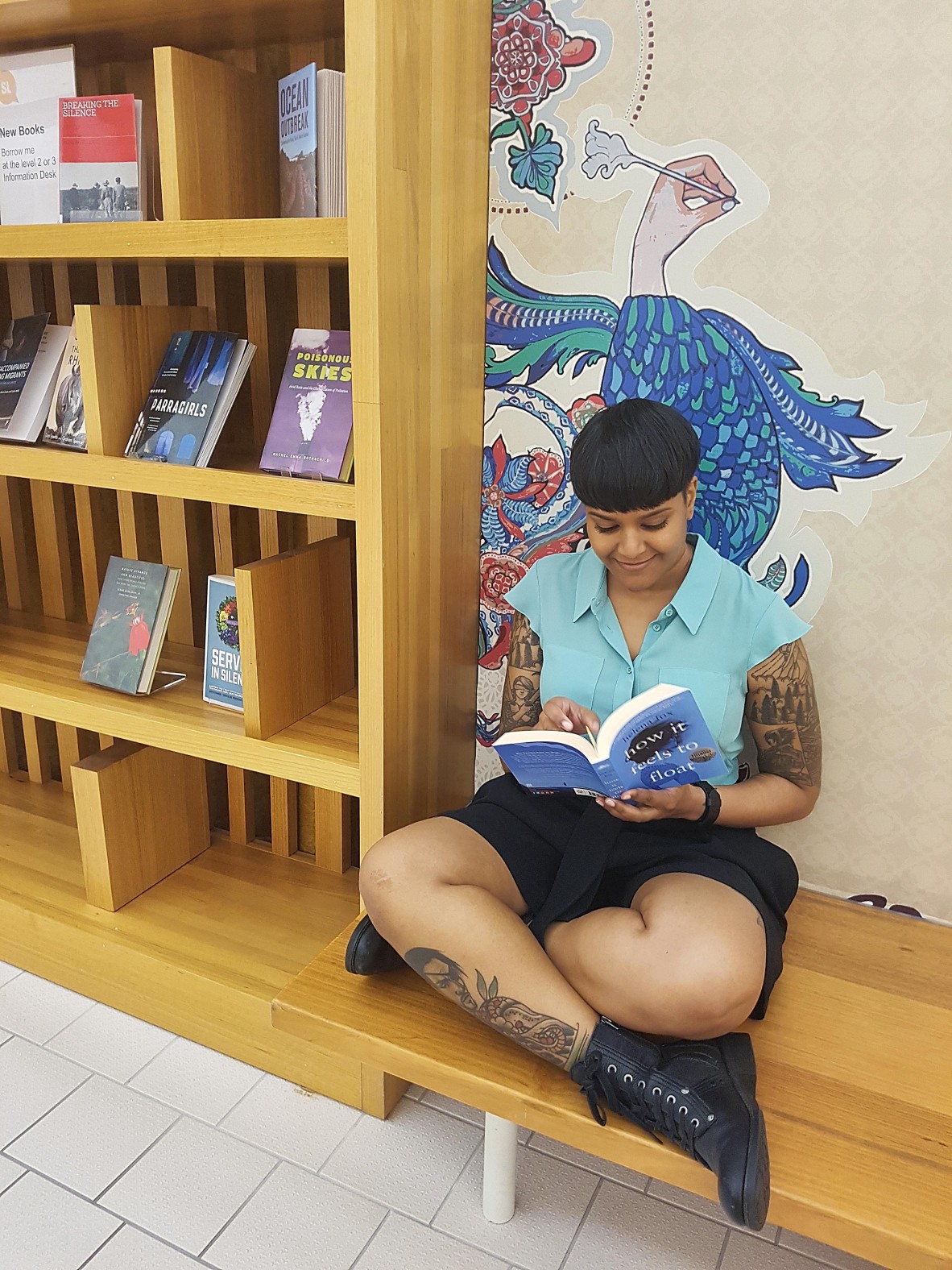 Shastra Deo sitting cross-legged while reading a book