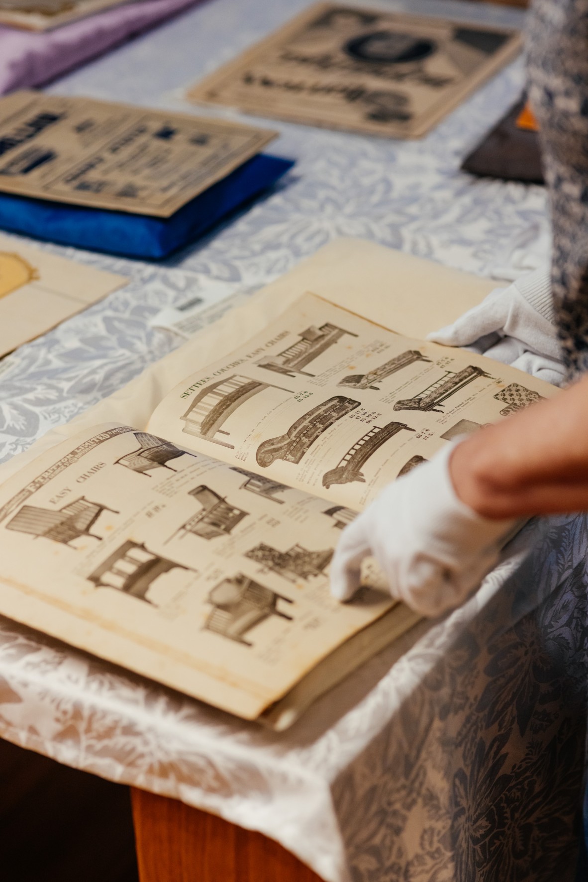 Members of the Tritton's family looking over collections relating to their grandfather, Fred Tritton's furniture company.