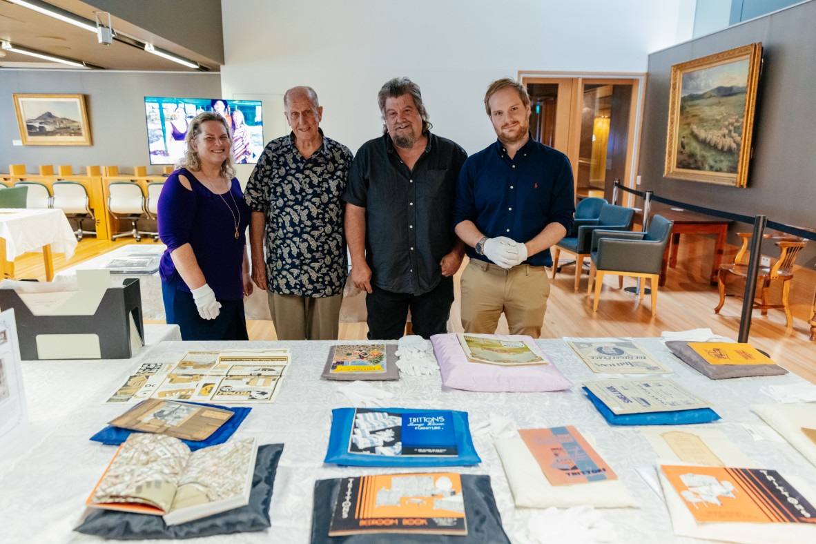 Members of the Tritton's family looking over collections relating to their grandfather, Fred Tritton's furniture company.
