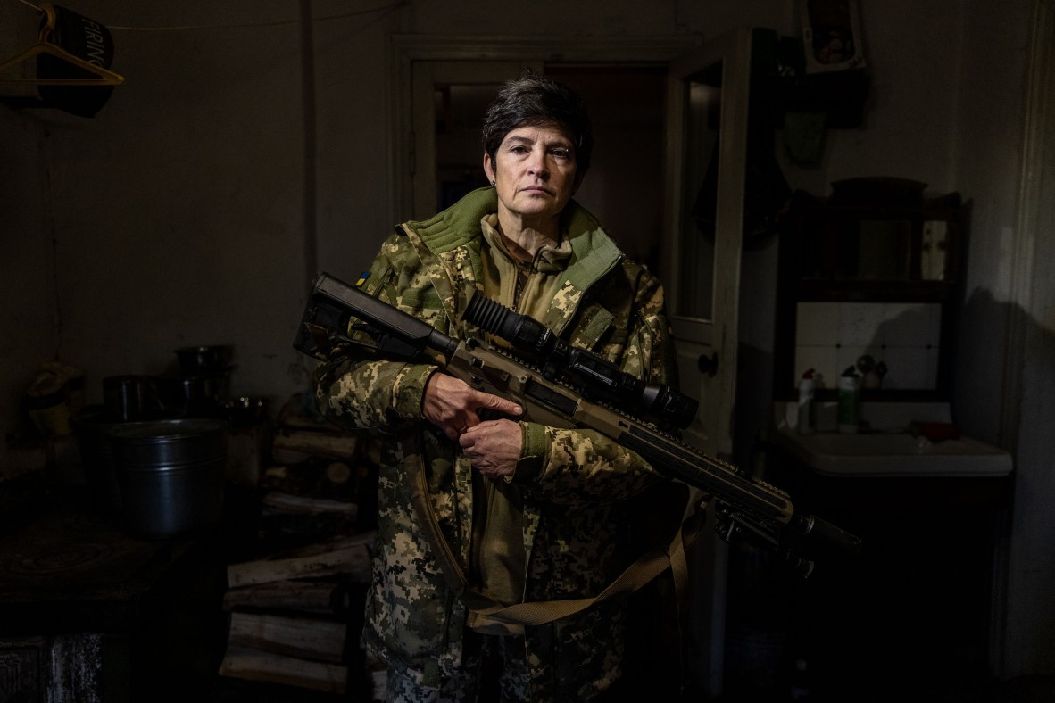 A photo of a woman in army clothing holding a gun