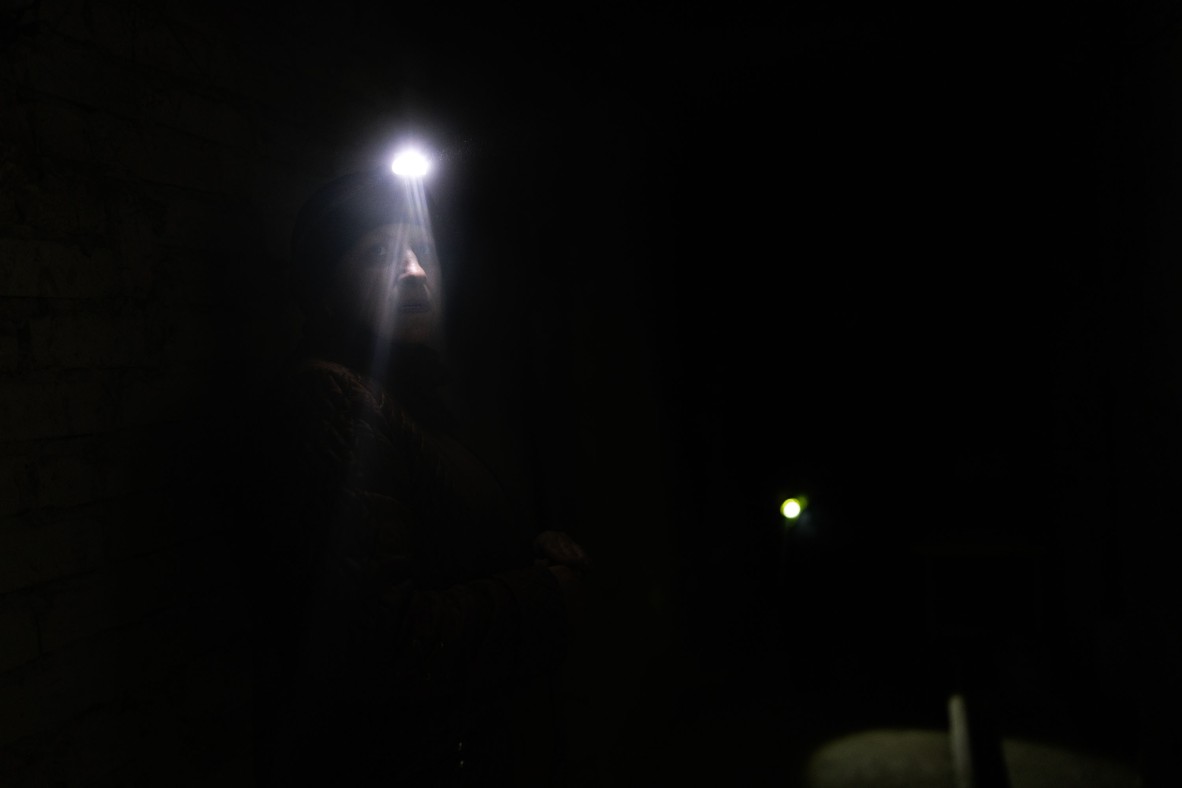 A photo of someone in the dark with only a head lamp