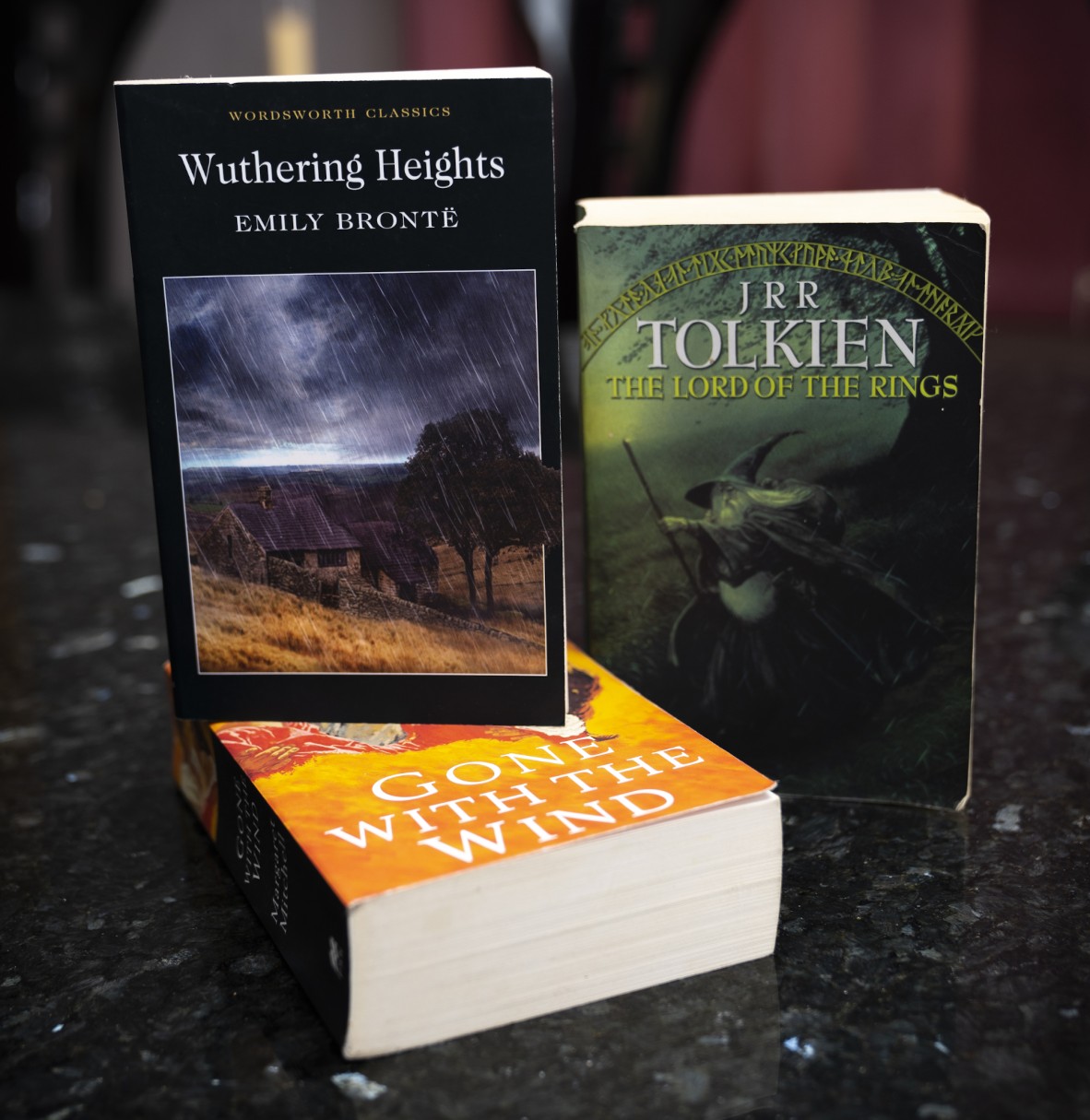 The books Wuthering Heights The Lord of the Rings and Gone with the Wind stacked on a counter