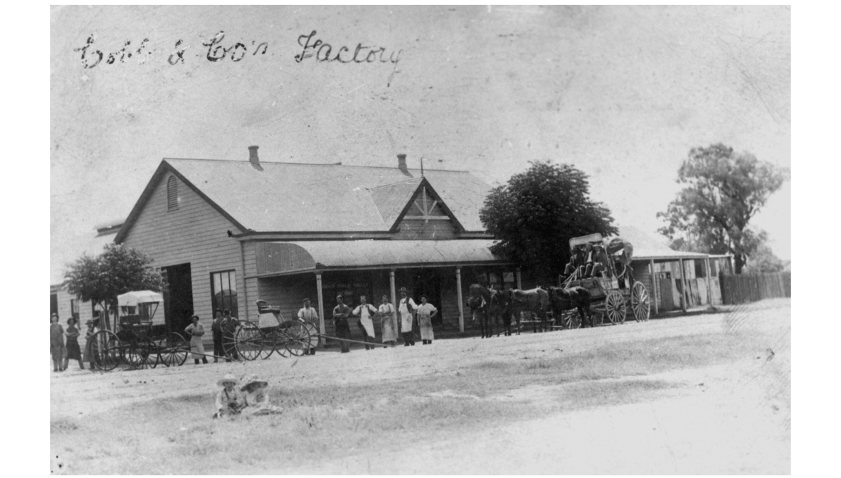 Photograph of the Cobb and Co. factory in Charleville, in 1911. There is a horse drawn coach out the front, with various staff posed.