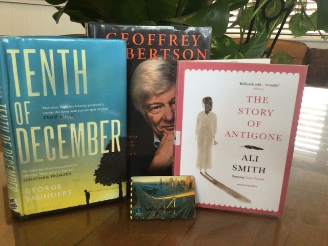 Three books sit on a table: Tenth of December, Rather His Own Man and The Story of Antigone. Amanda's BCC library card rests in front.