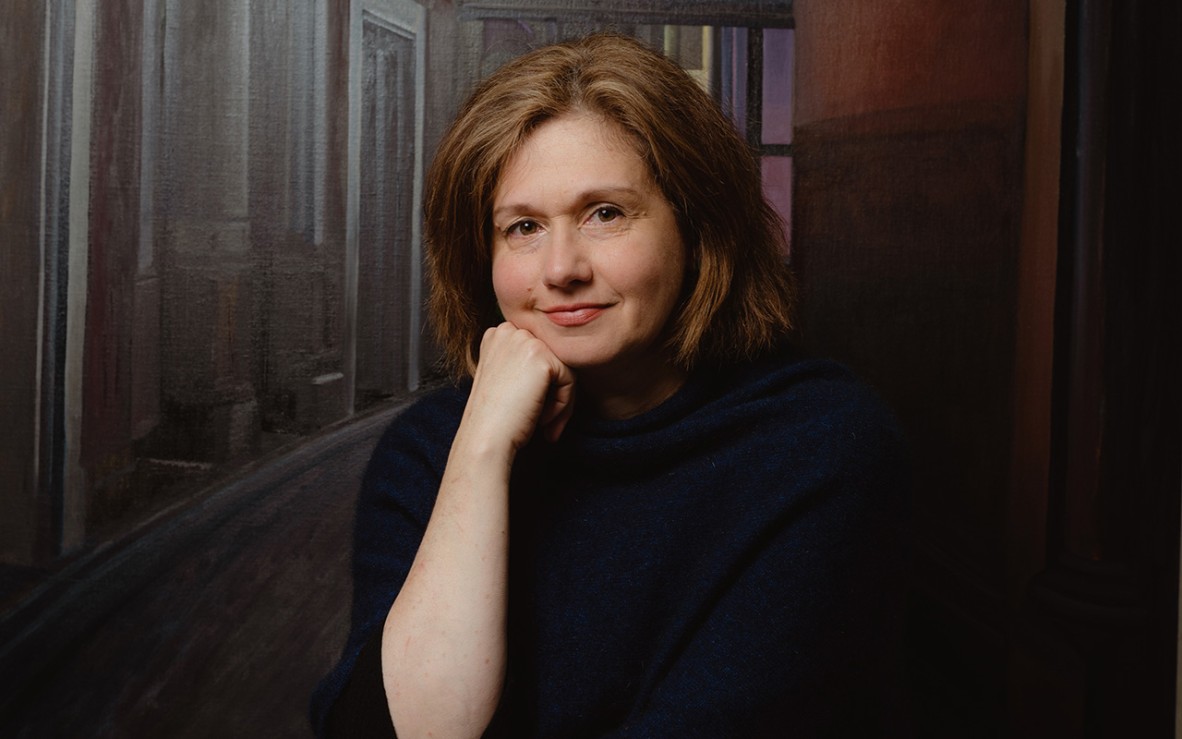 woman in black jumper in front of painting