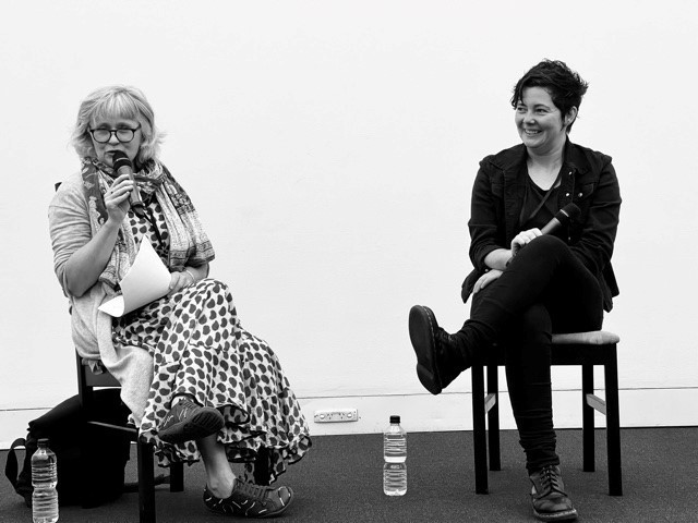 A black and white image of Ashley Hay and Grace Lucas-Pennington sitting down and talking at Brisbane Writers Festival 2021. 