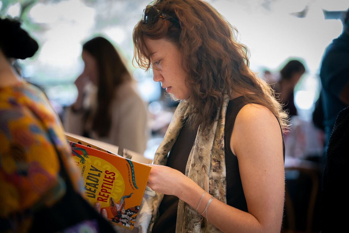 Audience member of Indigenous Languages Forum holding Deadly Science book, 2026