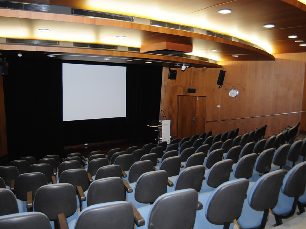 An empty auditorium with large screen and podium at front