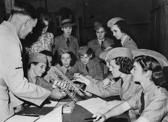 A group of women looking at a model aeroplane