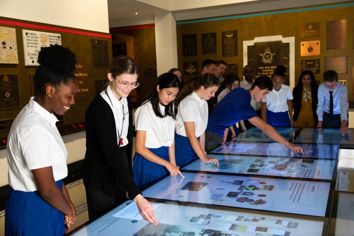 Group of students interacting with touch screens at Anzac Square Memorial Galleries