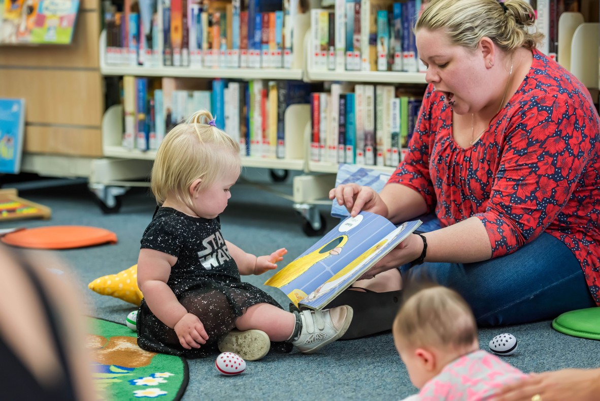 Mother and baby reading a book in Walkston Library, Mackay