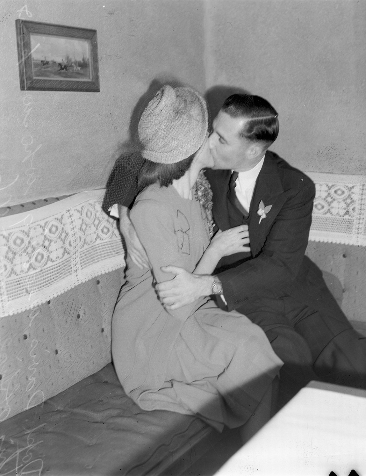 Black and white image of newly married couple kidding in a cafe booth.