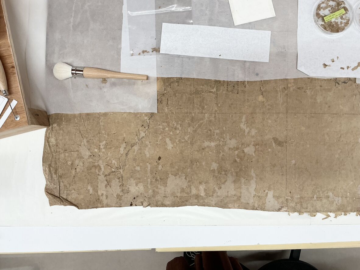 Working on the map section-by-section, keeping treated areas covered with paper to protect them from the elements. Loose fragments were set aside, and any pieces with media on them were kept separately, just in case their original placement could be located later on.