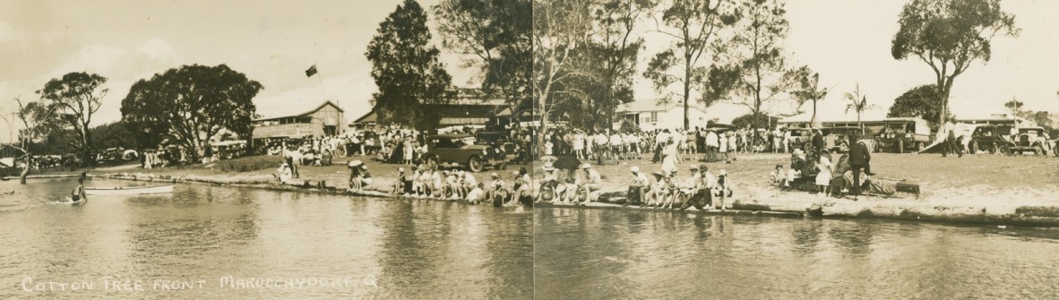Sepia panorama image of crowds of holiday-makers gathered on the banks of the Maroochy River at Cotton Tree Maroochydore Queensland ca 1928