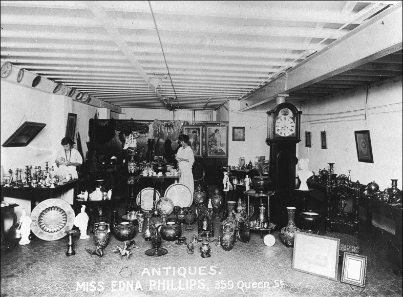 Woman standing in middle of room surrounded by antiques