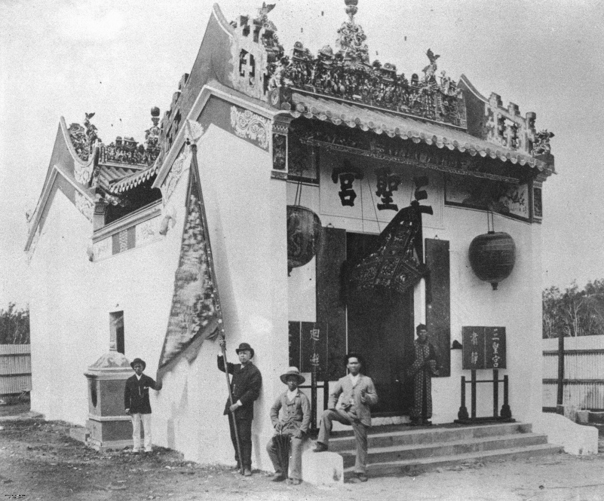 A picture of a Chinese temple with three men outside