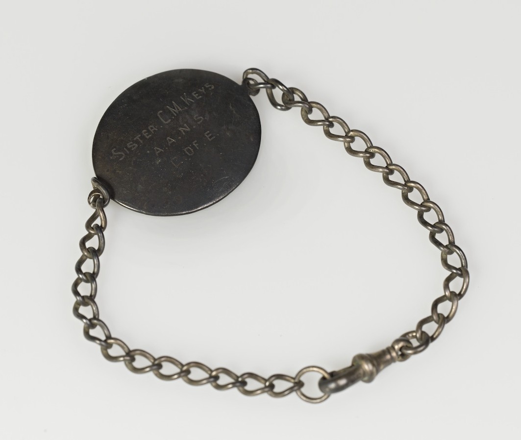 An identity bracelet that reads 'SISTER C.M. KEYS A.A.N.S. C. OF E.'