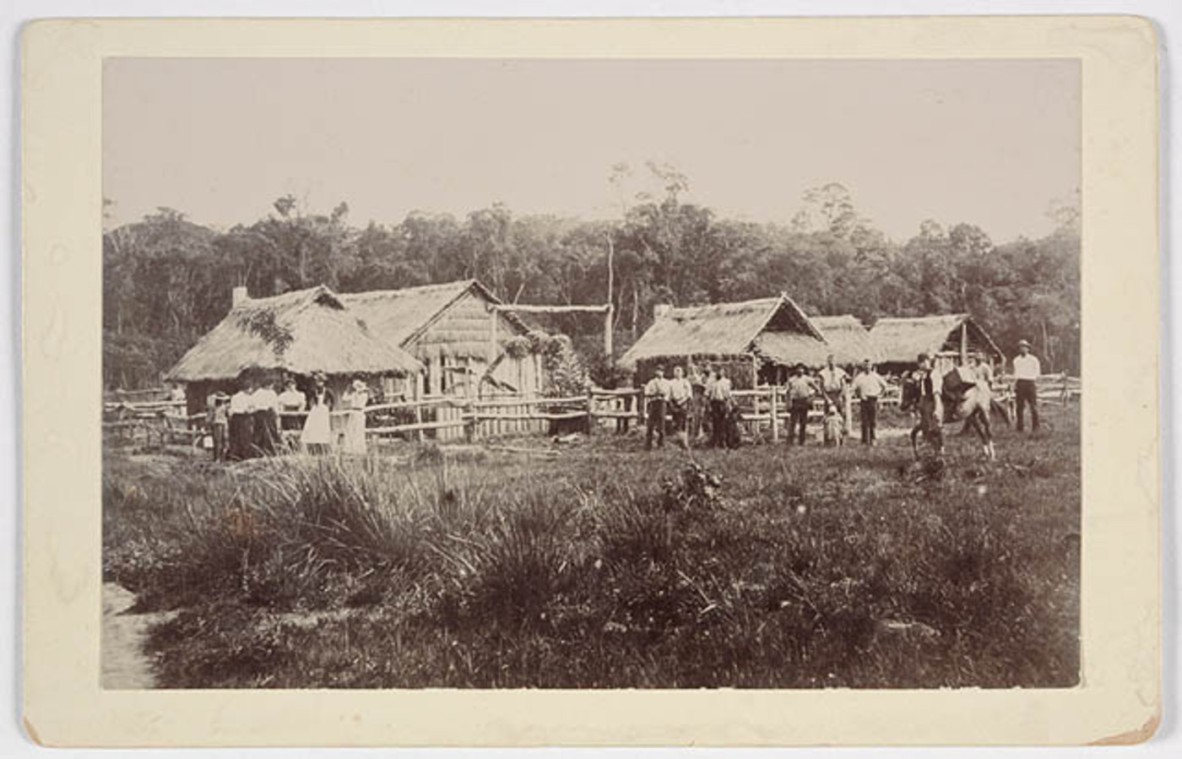 Groups of people in front of huts