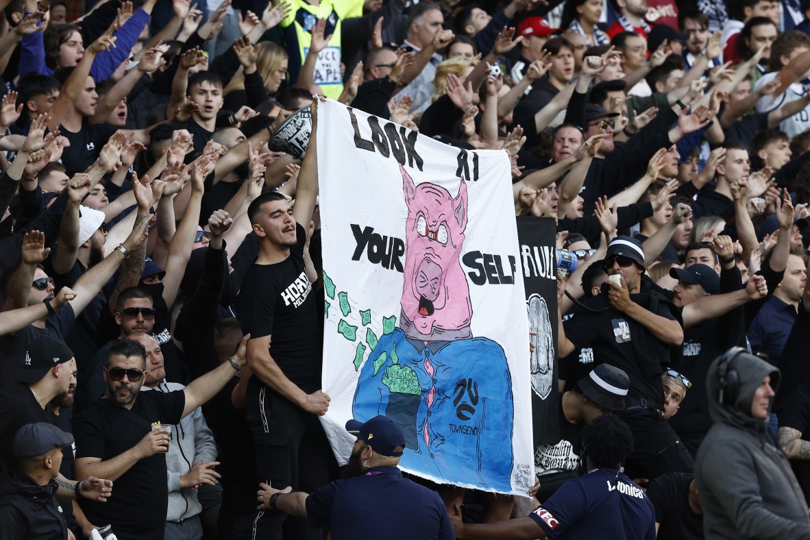 Photo of fans at a football match holding a sign that says look at yourself