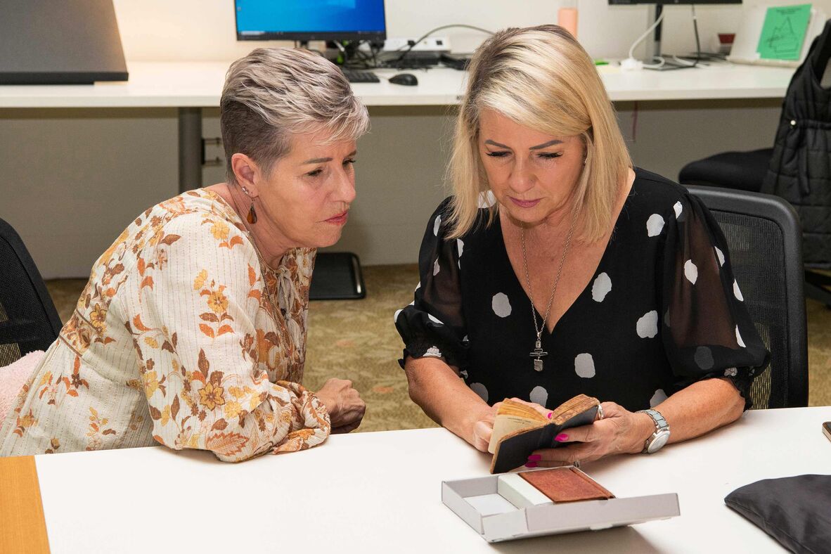 Two women looking at old diary