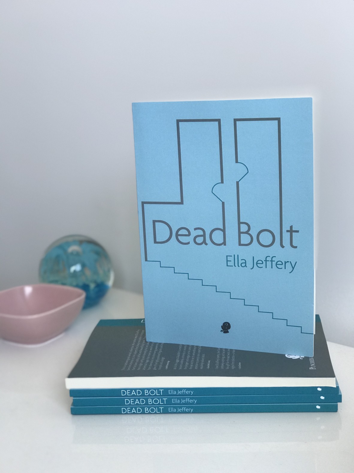 A stack of Ella Jefferys book called Dead Bolt One copy sits upright on the stack the cover is light blue and features a minimalistic image of a floor plan