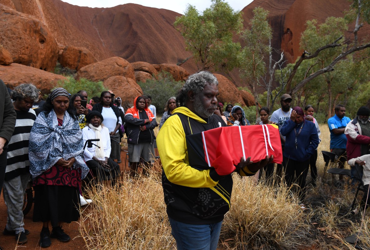 A photo of Aboriginal people gathered for a burial ceremony at Uluru