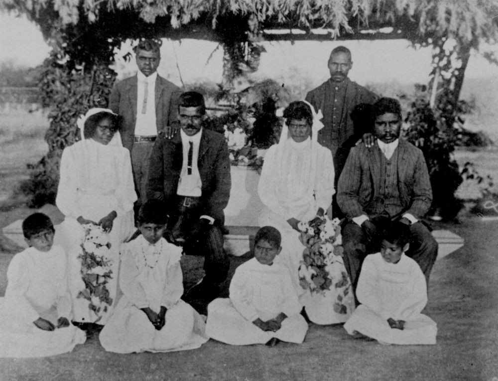 Two Aboriginal brides and their husbands seated with flower children