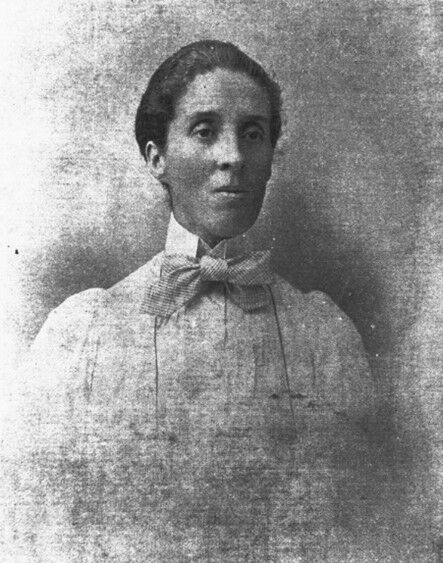 A picture of a woman wearing a dress with a bow at the neck