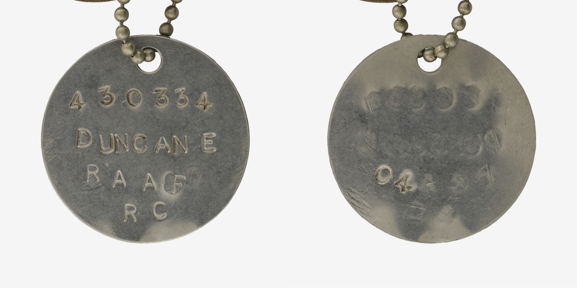 A circular WWII RAAF identity disc. It reads '430334 DUNCAN E RAAF RC O4.'