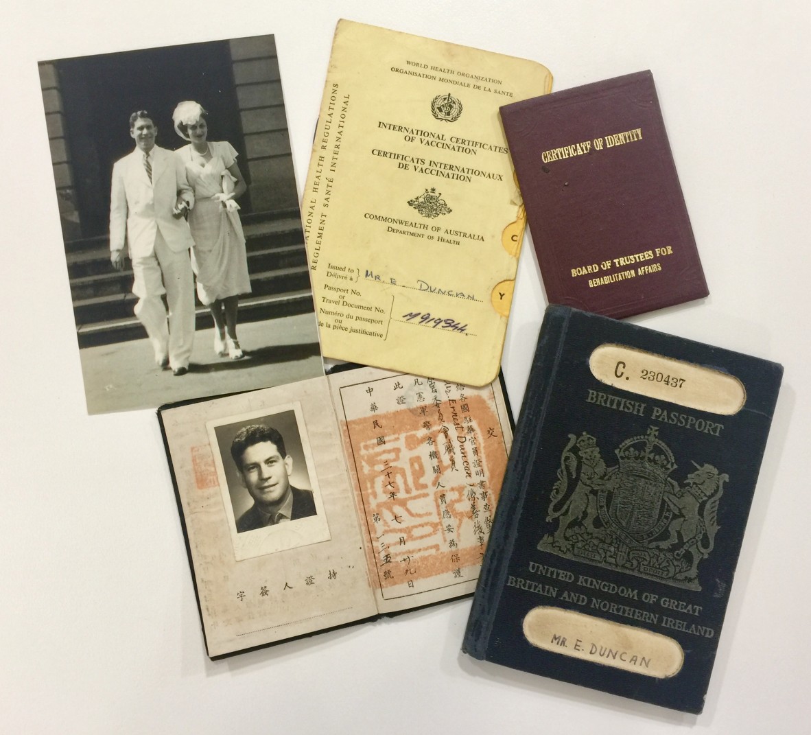 Ernest's personal documents: a wedding photo, a vaccination certification, a passport, a certification of identity on a table.