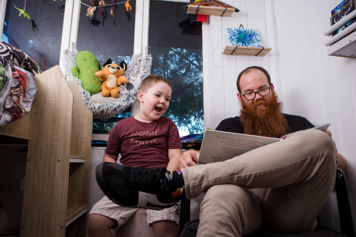 Father and young son reading and singing rhymes