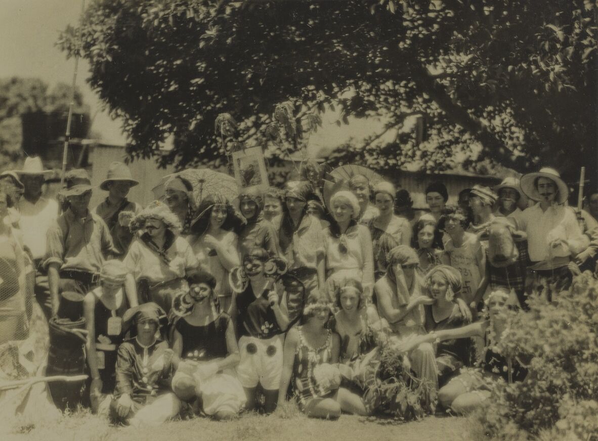 Embury Family photographs (0001-0038). A group on a scientific expedition to the Great Barrier Reef entertain with some fancy dress, c1931. Some costumes would have been deliberately included in their luggage to the Norwest Island or loaned between women and men.