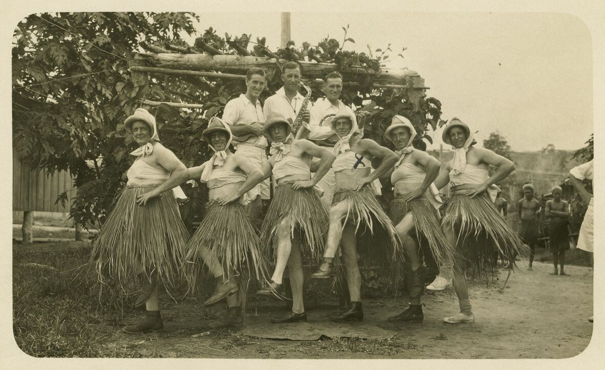 Australian men who were working gold dredging in Bulolo, Papua New Guines, entertain their fellow workers c1930s. Their skirts are made from local materials.