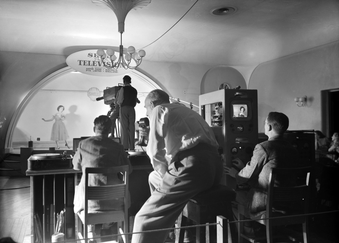 Female dancer performs while a camera operators film at the Shell Presents Television event at Lennons Hotel in Brisbane, 1949