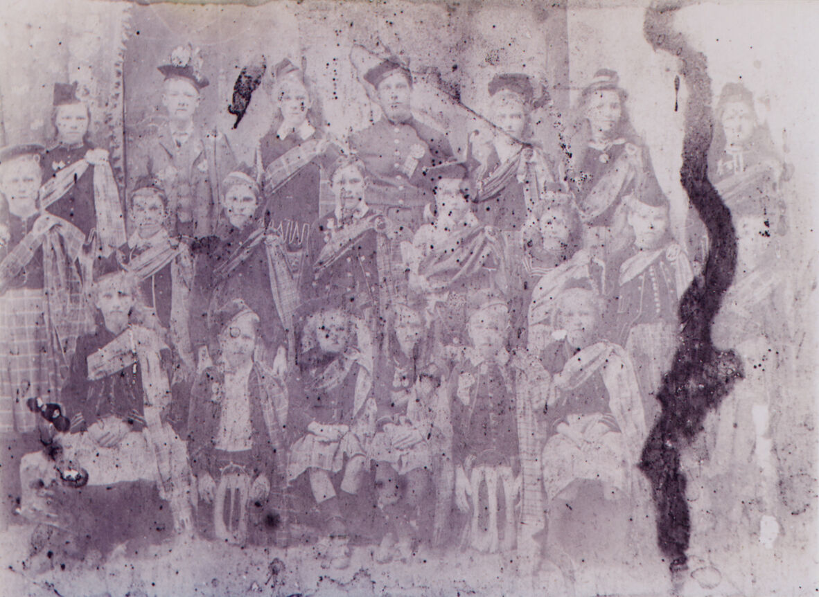 Group of men, women and children dressed in Scottish dress for Halloween, 1908.