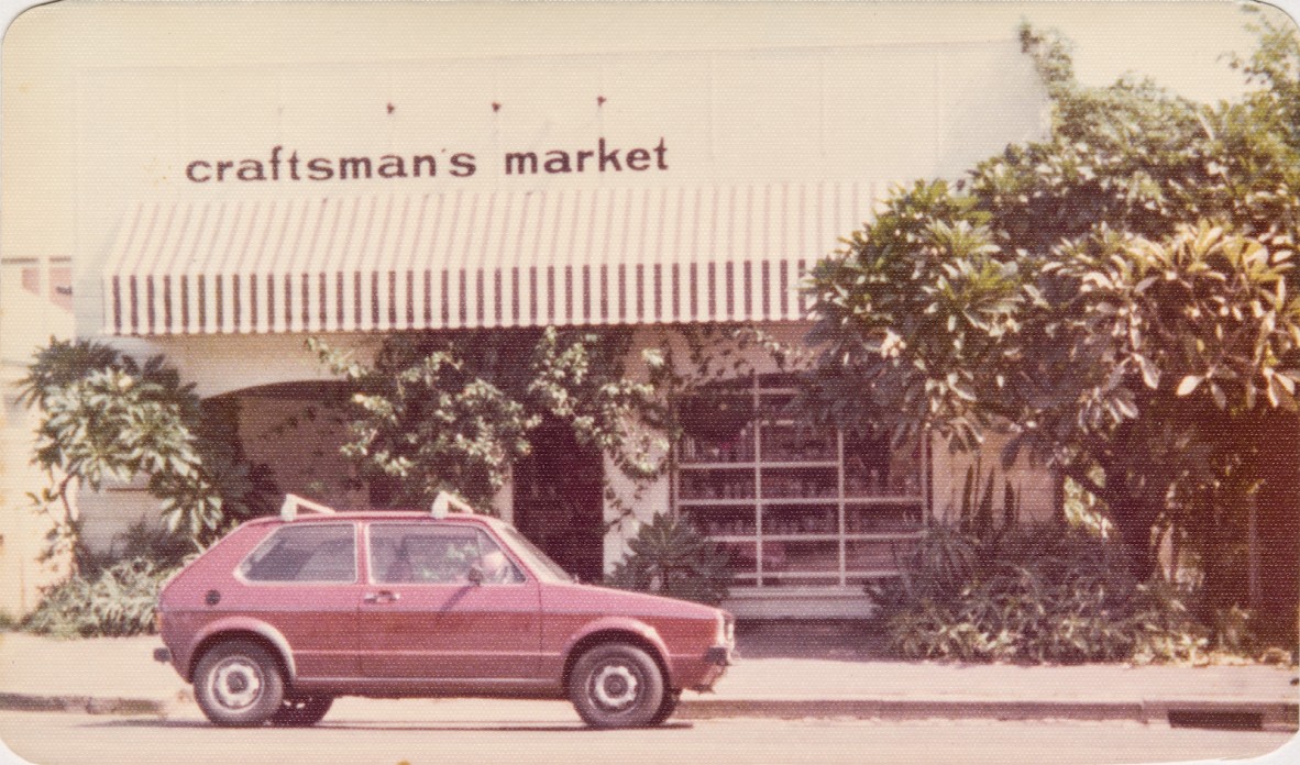 The 1970s façade of the Craftsman's Market with a red Volkswagen Golf parked in front.