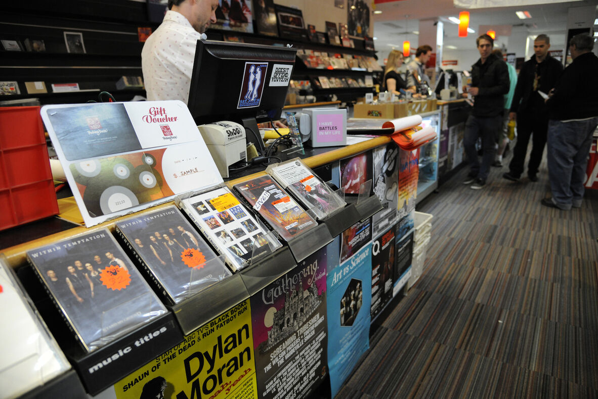 The inside of a record shop showing customers, CDs and staff at a counter