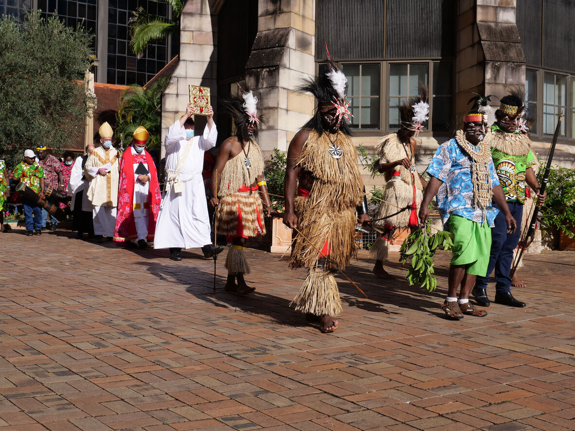 A procession of religious leaders and men and women in traditional and modern dress outside St John's Cathedral during The Coming of the Light celebrations, Brisbane, 2021