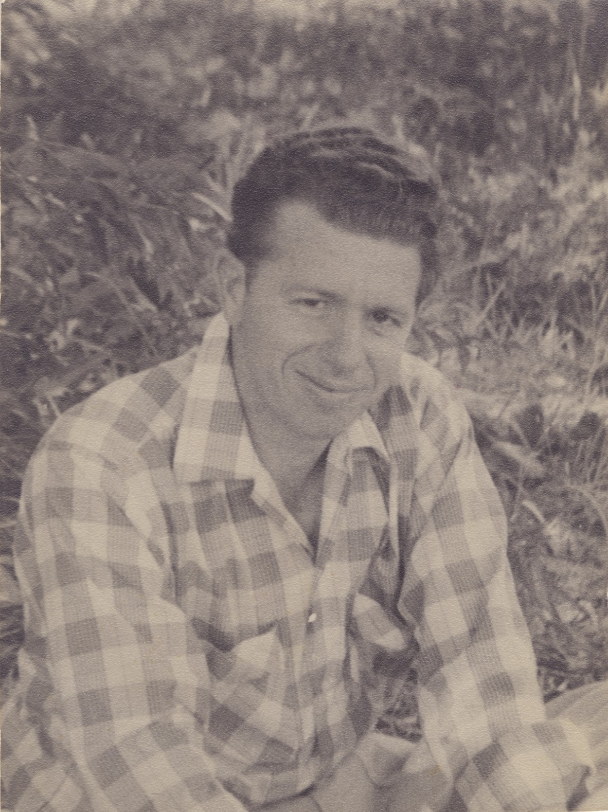 Black and white photograph of a young Kevin Anderson sitting on the grass