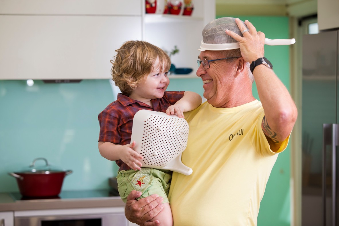 Child and grandfather playing in the kitchen