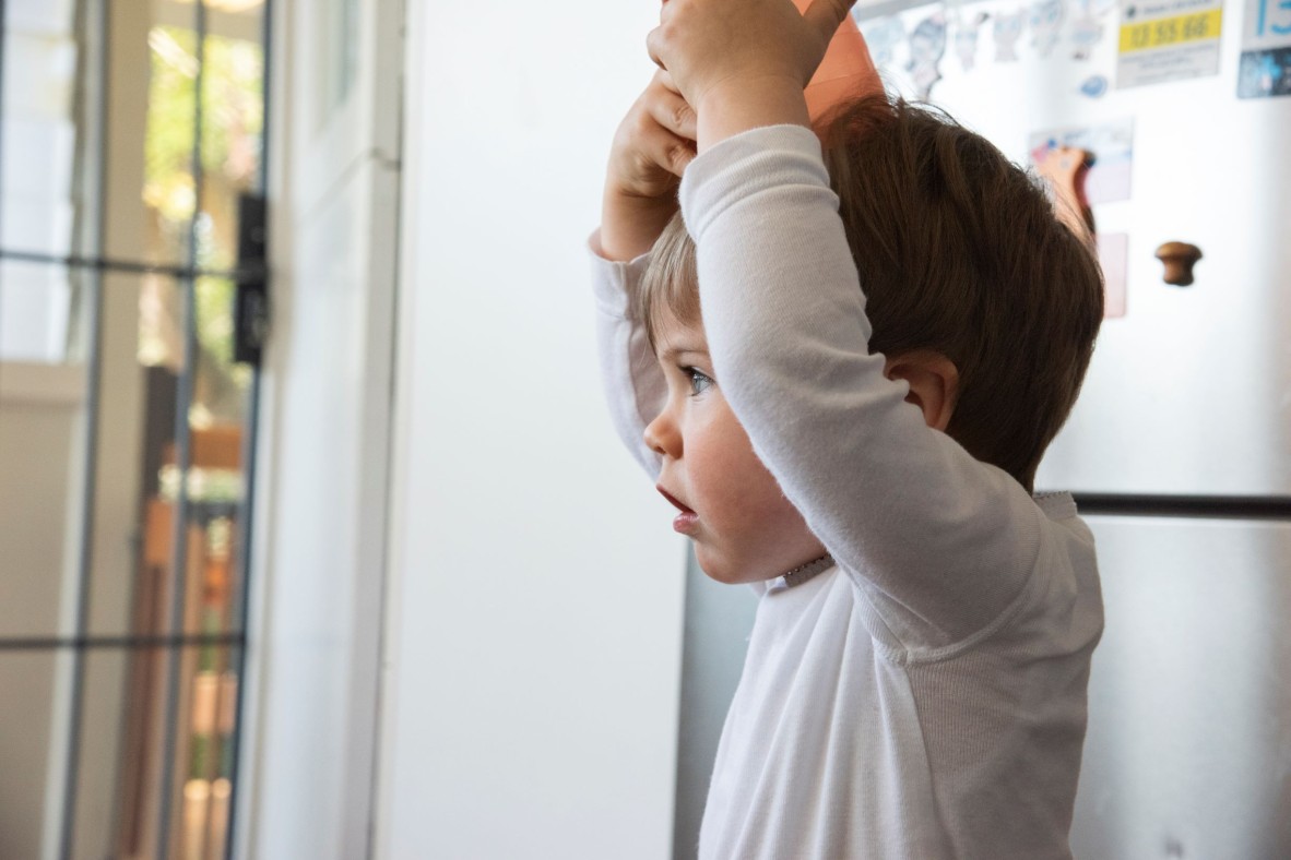 Toddler balancing a toy on his head